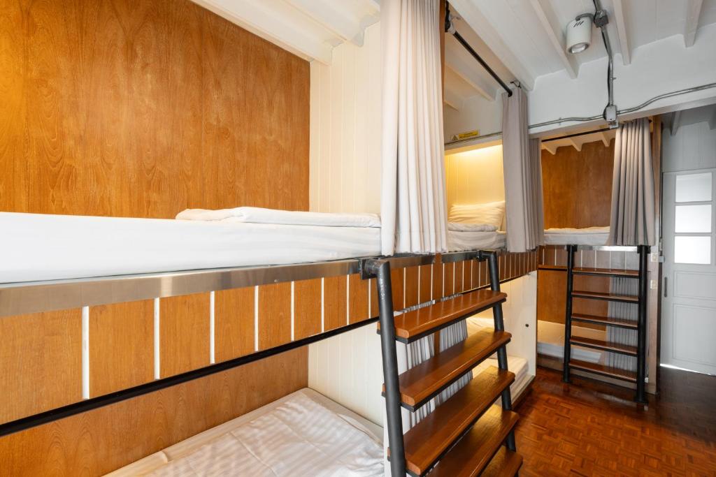 チェンマイにあるBed Addict Hostelの二段ベッド2組と階段が備わる客室です。
