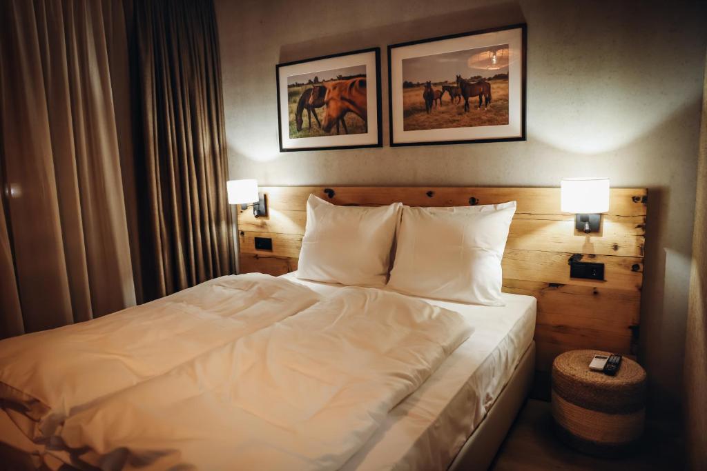 - un lit dans une chambre d'hôtel avec 2 photos sur le mur dans l'établissement Hajé Nieuwegein, à Nieuwegein