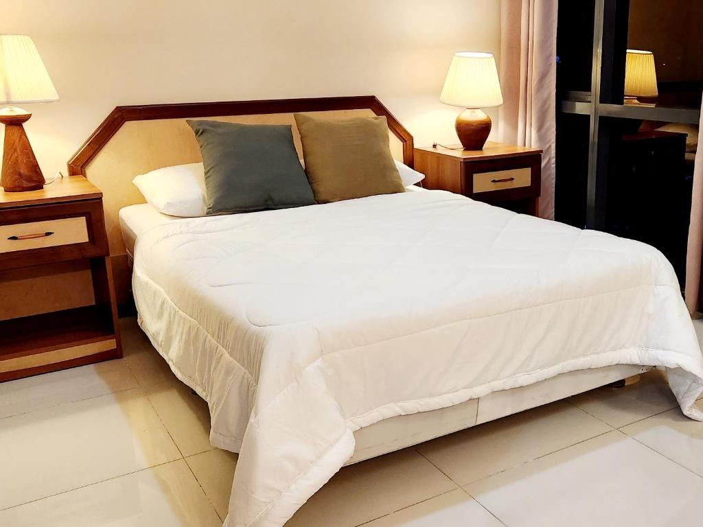 a bedroom with a large white bed with two night stands at Casa Antonio at Viceroy McKinley Hill in Manila