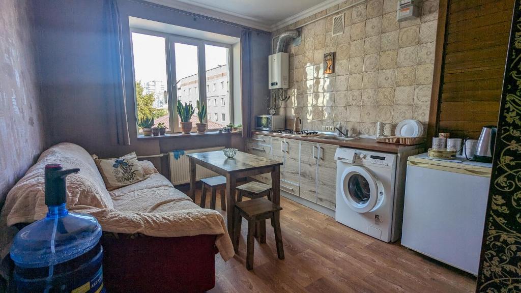 a kitchen with a washing machine and a table at Двухкомнатная Квартира на Пятницкой in Chernihiv