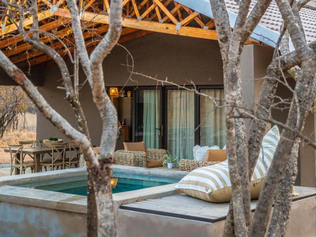 une maison avec une piscine à côté de quelques arbres dans l'établissement Minara Private Boutique Game Lodge, à Dinokeng Game Reserve