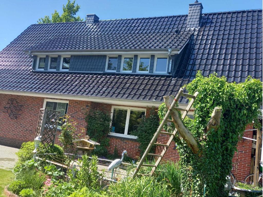 a red brick house with a ladder in the yard at Haus Katharina in Barßel