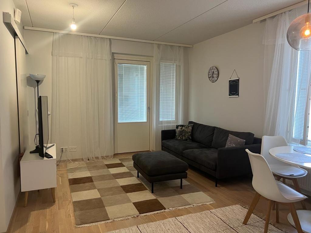 a living room with a couch and a table at Cozy Aparment with sauna nearby Airport in Vantaa