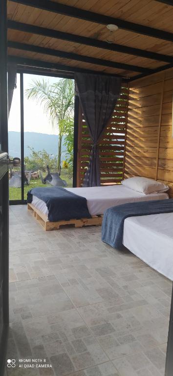 ピエデクエスタにあるCabañas de la lomaの海の景色を望む客室で、ベッド2台が備わります。
