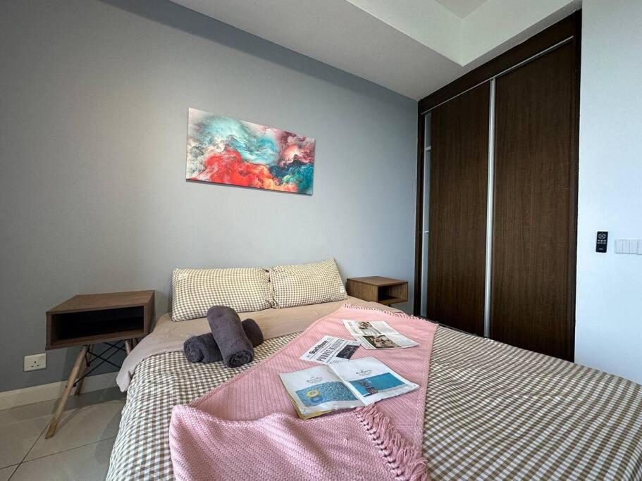 um quarto com uma cama com um cobertor rosa em A1804 Grand Medini Studio 100mbps Netflix By STAY em Nusajaya