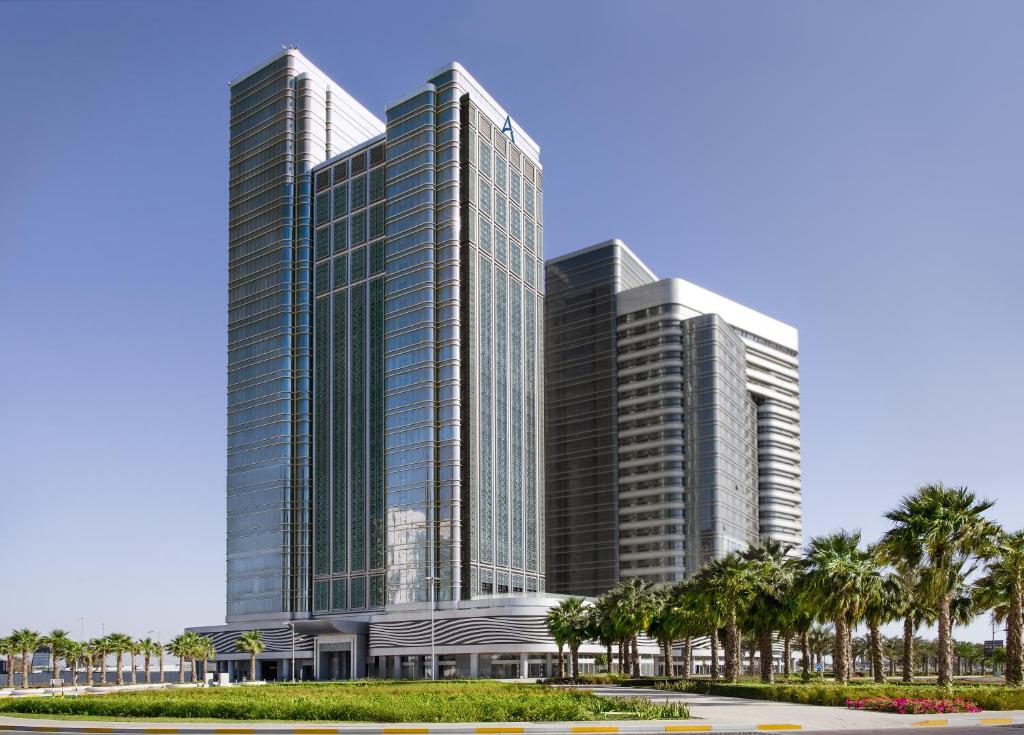 a rendering of a tall building with palm trees at Capital Centre Arjaan by Rotana in Abu Dhabi