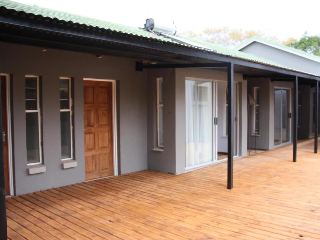 una fila di case con terrazza in legno di Blesbok Inn a Polokwane