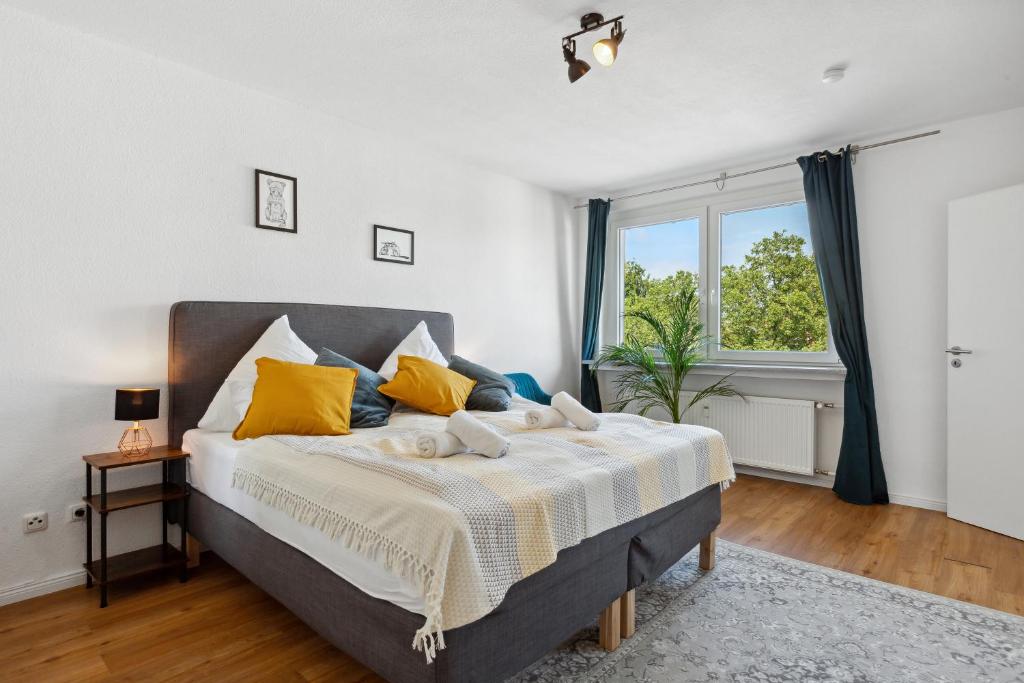 um quarto com uma cama grande e almofadas amarelas em E&K Apartment Kahrstraße em Essen