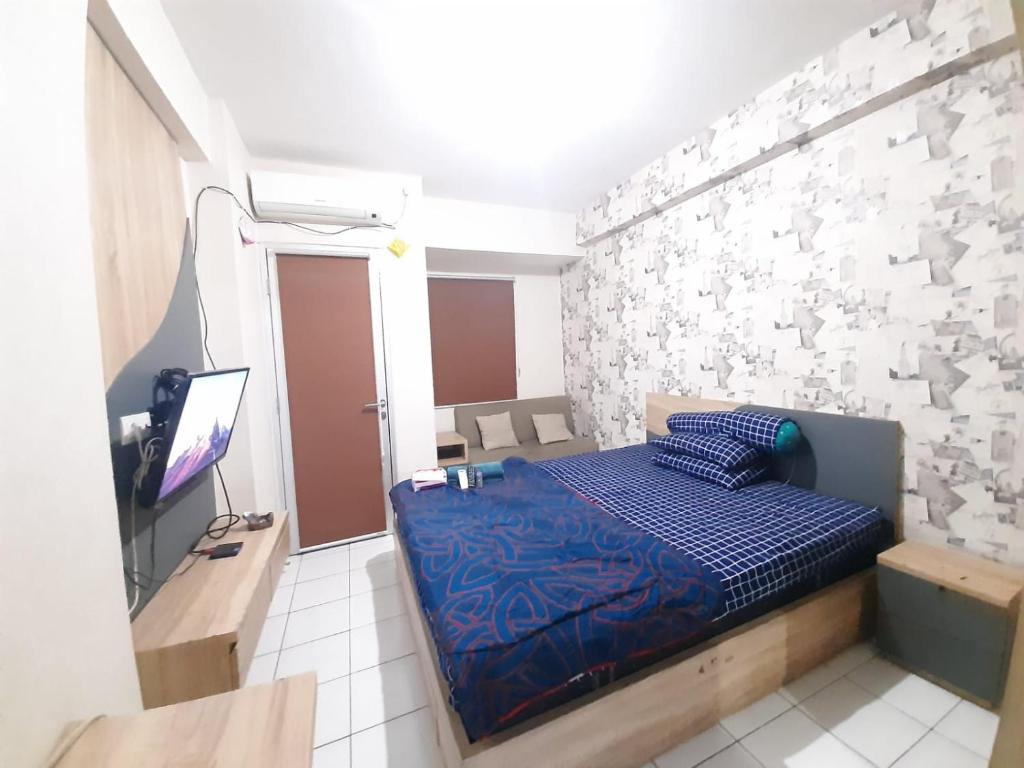 ein kleines Schlafzimmer mit einem Bett und einem TV in der Unterkunft Sewa apartemen/transit gunung putri square Bogor in Parungtandjung