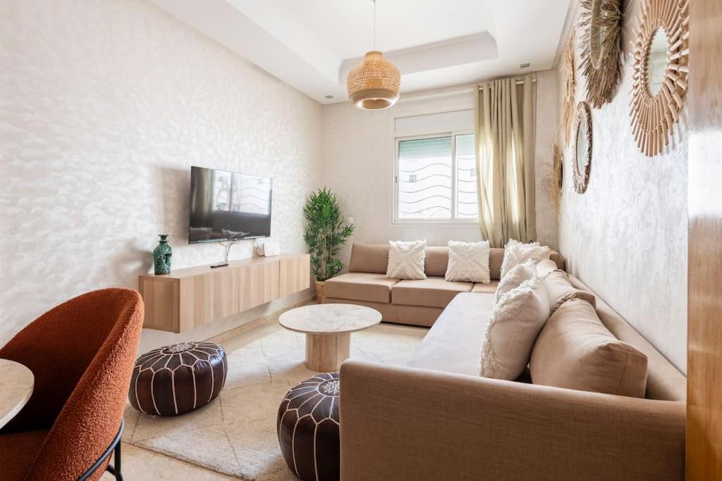 a living room with a couch and a tv at TT Holidays Cosy Apartment Hassan in Rabat