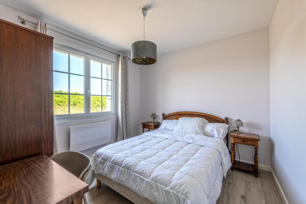 a bedroom with a bed and a window at Beach House 1km de la plage in Audierne