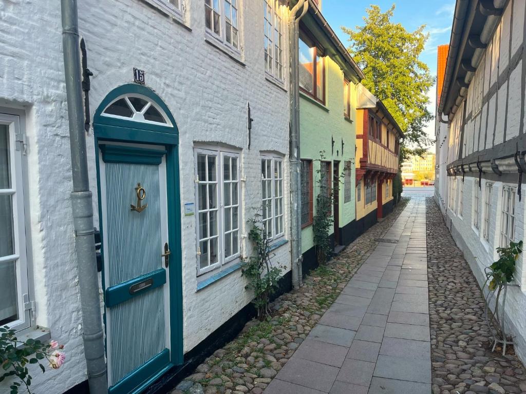 eine Gasse mit blauer Tür in einem weißen Gebäude in der Unterkunft fewo1846 - Kaete-Lassen-Huus - uriges Häuschen auf 3 Ebenen mit Dachterrasse am Hafen in Flensburg