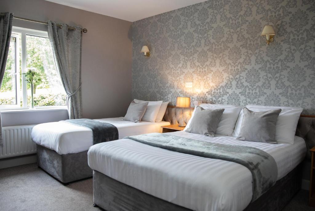 a hotel room with two beds and a window at Sliabh Beagh Hotel in Monaghan