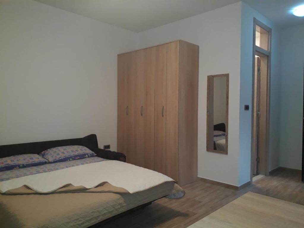 um quarto com uma cama e um armário de madeira em Apartmani Andrea Studio em Herceg Novi