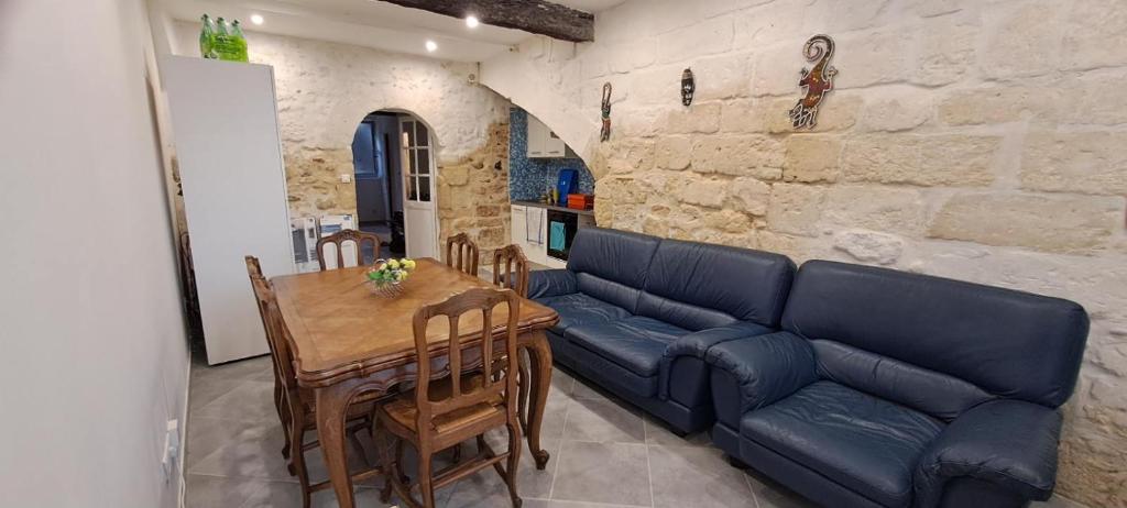 uma sala de estar com um sofá azul e uma mesa em Grande maison traversante. em Saint-Gilles