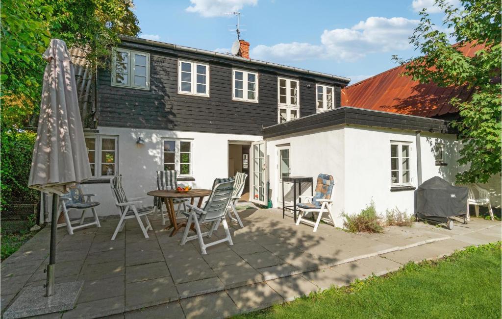 a patio with a table and chairs and an umbrella at 4 Bedroom Stunning Home In Sams in Brundby