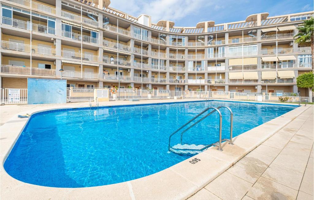 una piscina frente a un gran edificio de apartamentos en Lovely Apartment In Campello With Kitchen en Aigues