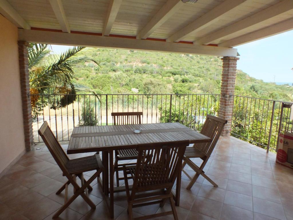 モンテ・ナイにあるVilla Isabelの木製テーブルと椅子付きのバルコニーから眺めの良い景色を楽しめます。