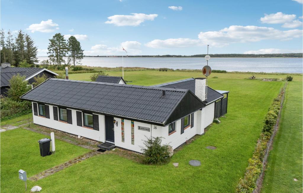 una casa blanca con techo negro en un campo de hierba en Lovely Home In Storvorde With Wifi en Storvorde