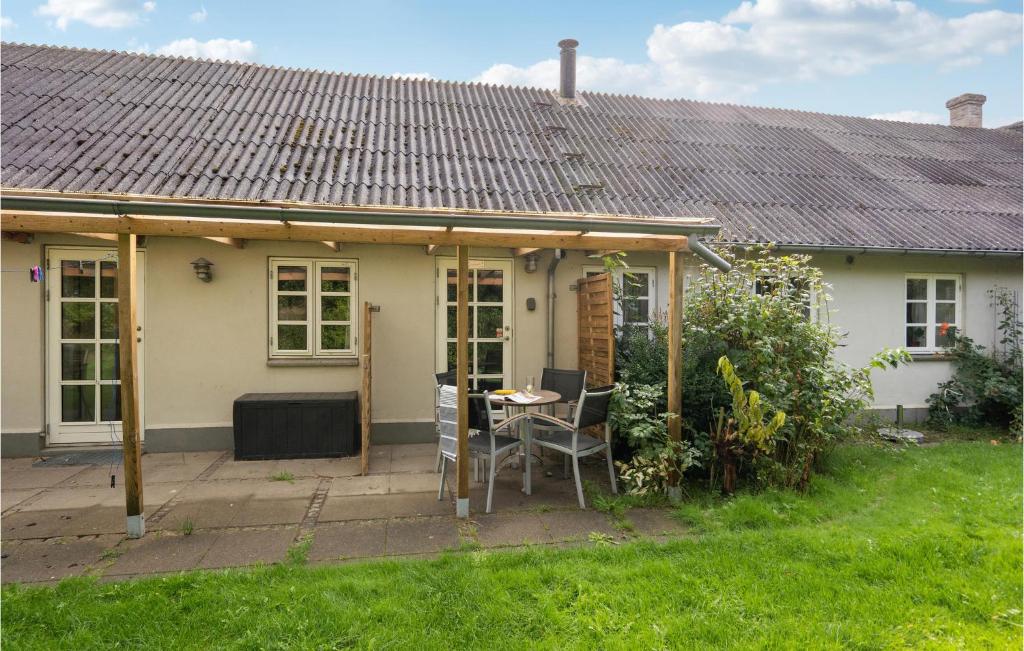 a small white house with a table and chairs at 2 Bedroom Pet Friendly Apartment In Ringkbing in Ringkøbing