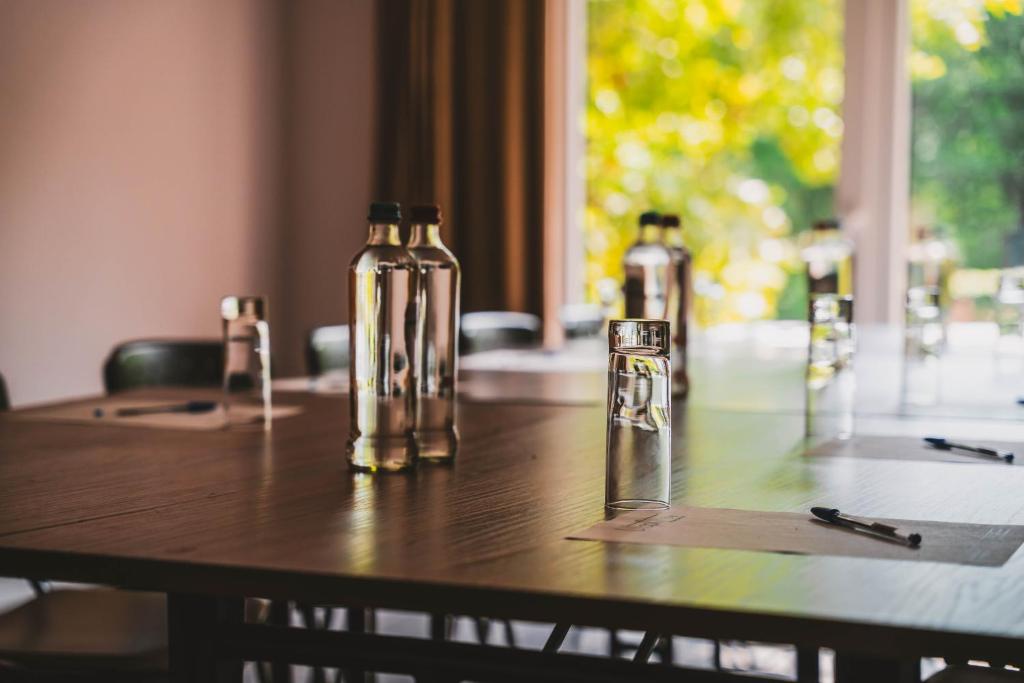 a wooden table with two bottles on top of it at Utopia Hotel - Art & Nature Hotel in Mons