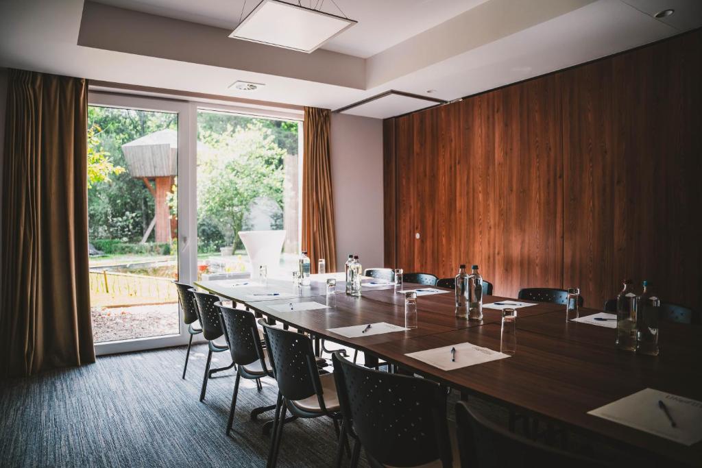 a conference room with a long table and chairs at Utopia Hotel - Art & Nature Hotel in Mons