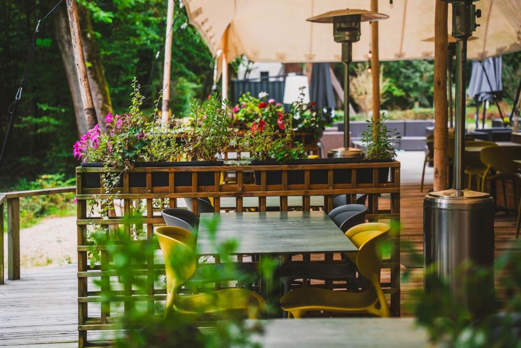 a table and chairs on a deck with flowers at Utopia Hotel - Art & Nature Hotel in Mons
