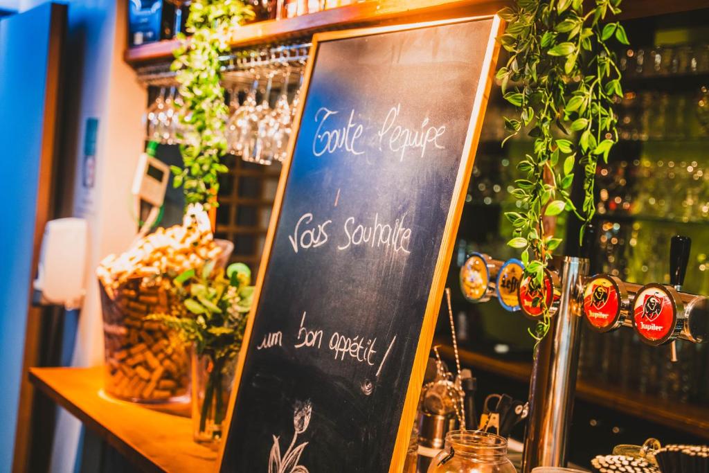 a chalkboard sign in front of a bar at Utopia Hotel - Art & Nature Hotel in Mons