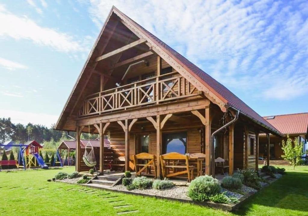 duża drewniana kabina z zielonym trawnikiem w obiekcie Domki Lawendowy Zakątek w Boszkowie