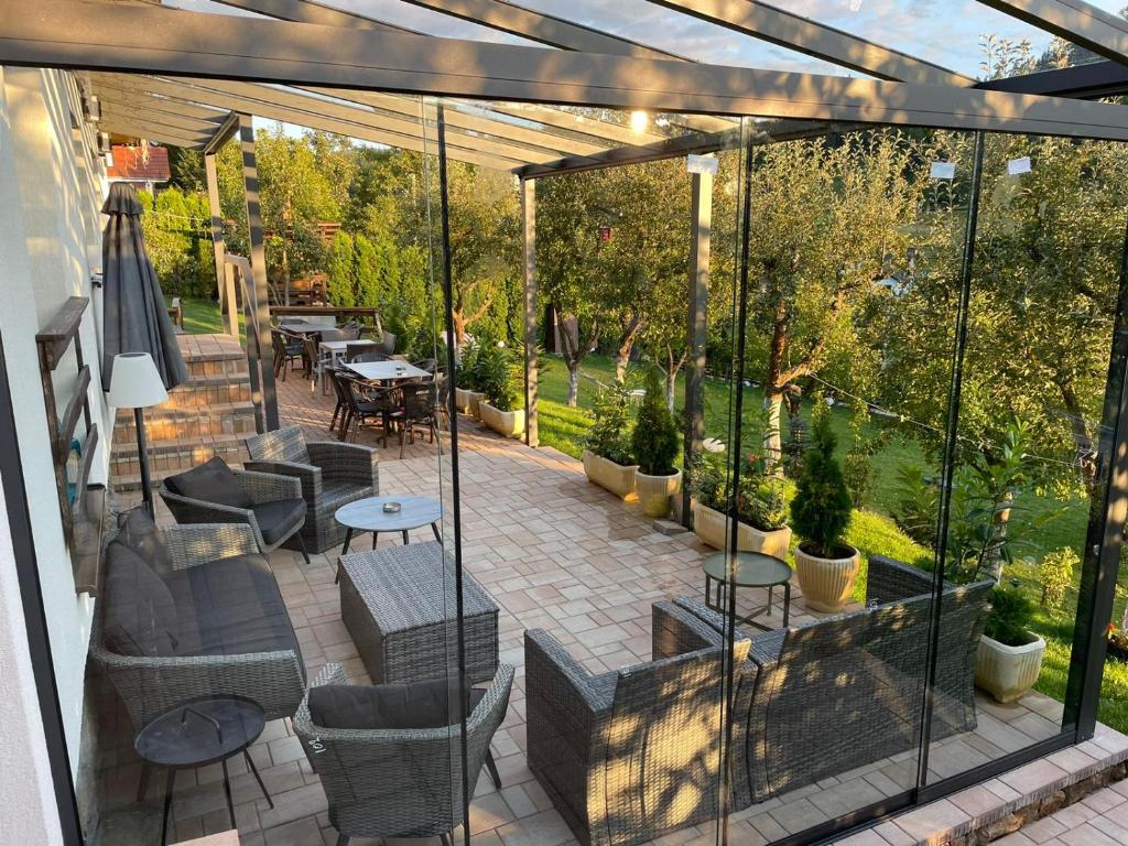 an enclosed patio with chairs and tables and trees at Cazare Colibita Casa Lipan in Colibiţa