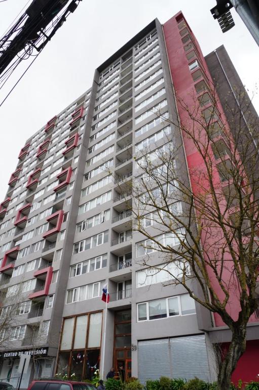 a tall apartment building with a fire truck at Apart Lomas de San Andres CENTRO in Concepción