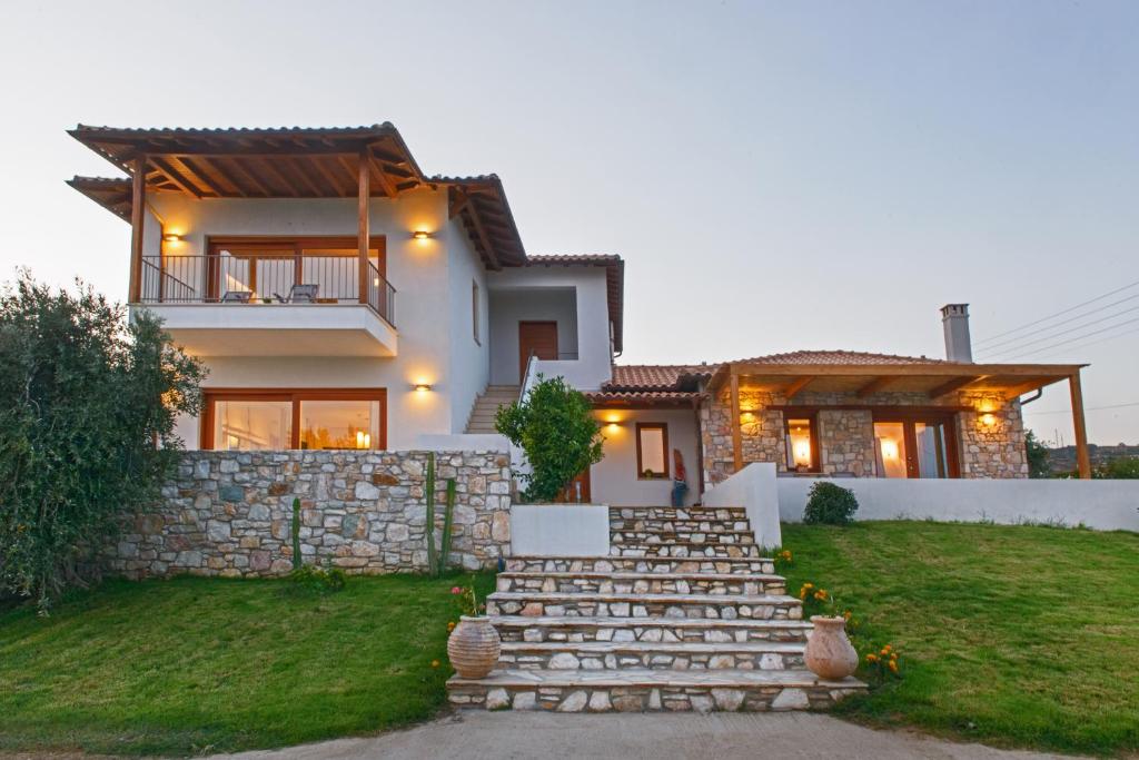 una casa con una escalera de piedra delante de ella en Villa Almira Luxury Apartments, en Ouranoupoli