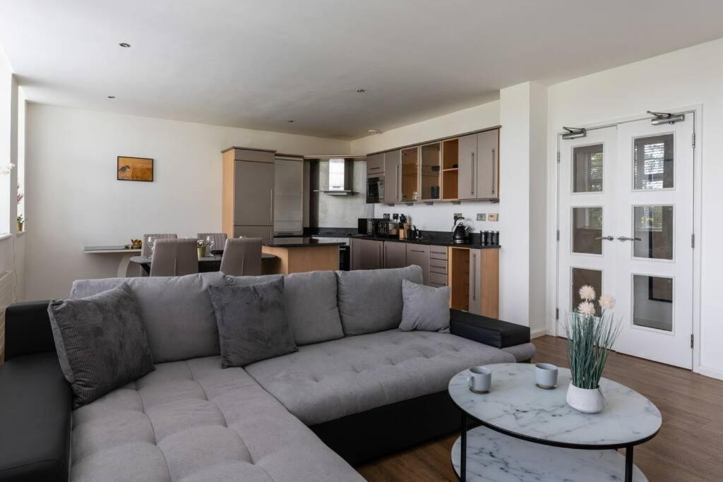 a living room with a couch and a kitchen at Central 2 Bed Pavilion Apartment in Brighton & Hove