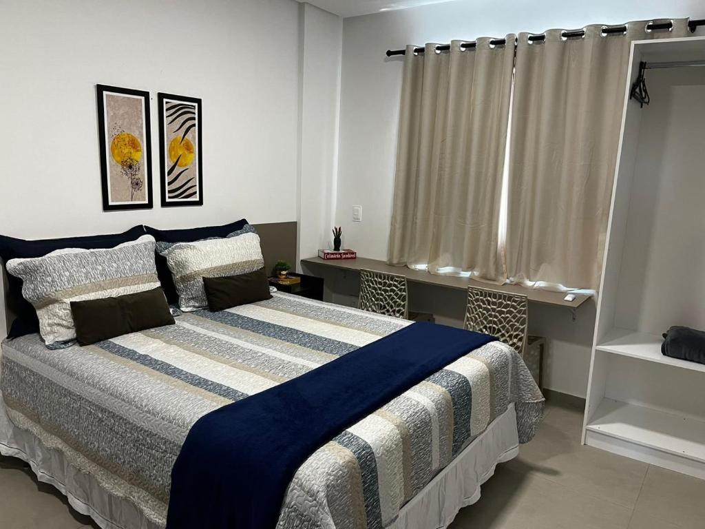 - une chambre dotée d'un lit avec une couverture bleue et blanche dans l'établissement Studio no West Fit Mossoró Alto Padrão, à Mossoró