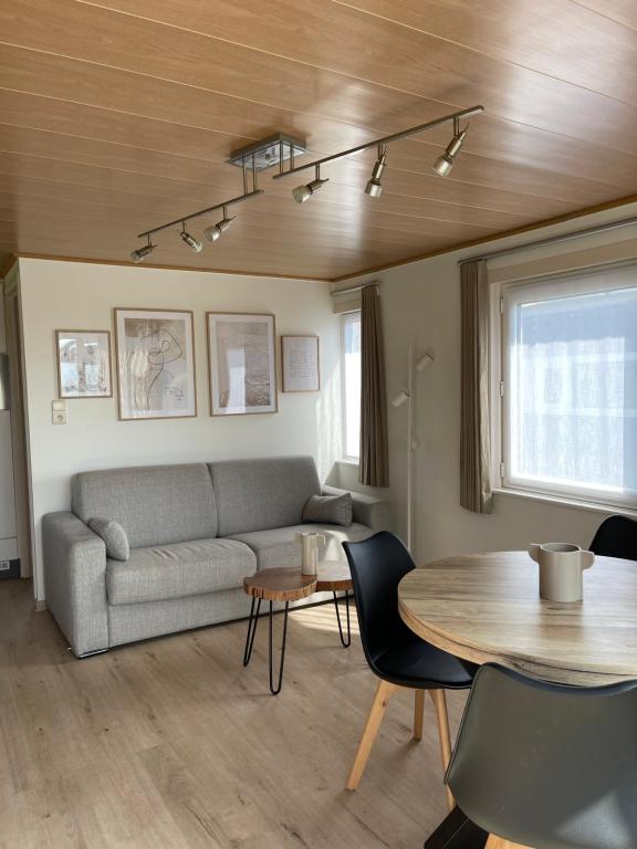 een woonkamer met een bank en een tafel bij Chalet n°32 in Middelkerke