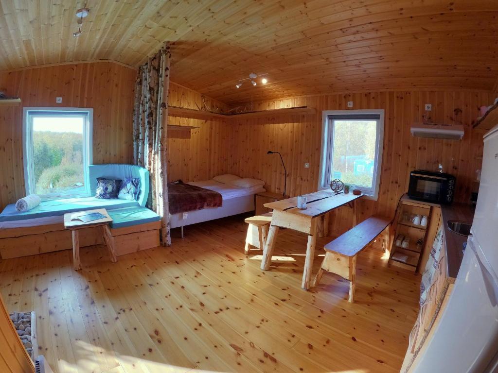 - une chambre avec un lit et un bureau dans une cabine dans l'établissement Wild Caribou's Wildwood Cabin, à Lakselv