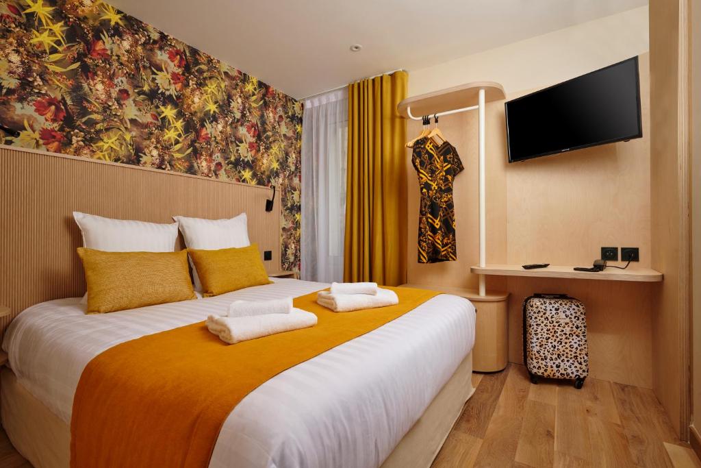 een hotelkamer met een groot bed en 2 handdoeken bij VLH Montparnasse Eiffel in Parijs