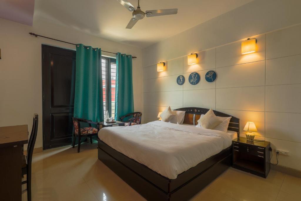 a bedroom with a large bed with green curtains at BED LUCKS near Huda Metro sector 40 in Gurgaon