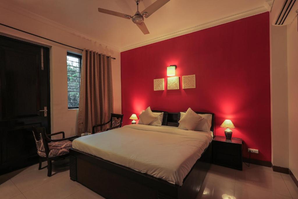 1 dormitorio rojo con 1 cama y pared roja en BED LUCKS near Huda Metro sector 40 en Gurgaon