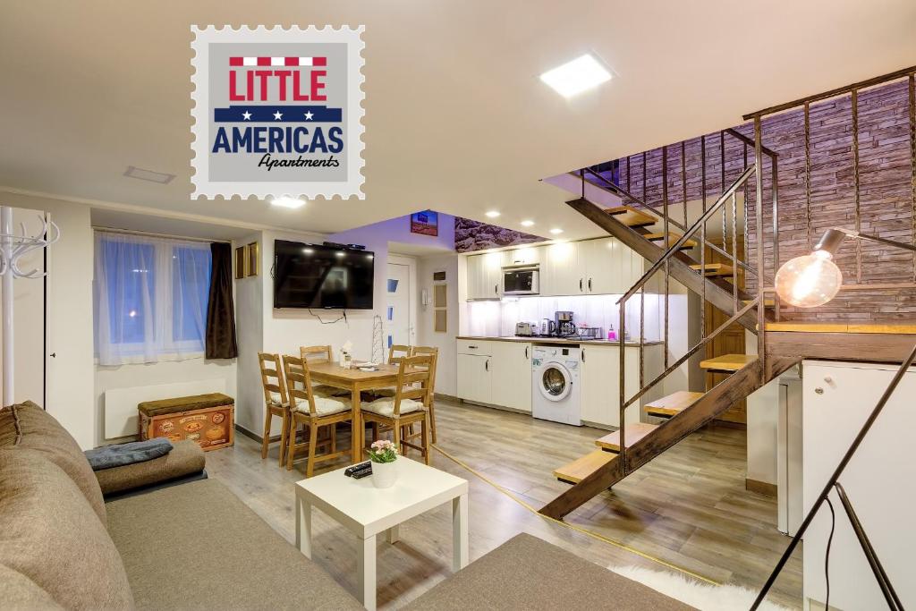 a living room with a staircase and a kitchen at Little Americas Parliament Apts in Budapest