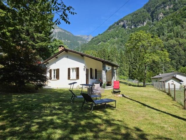a house with a table and chairs in a yard at Verzasca: Casa Sonia in Frasco