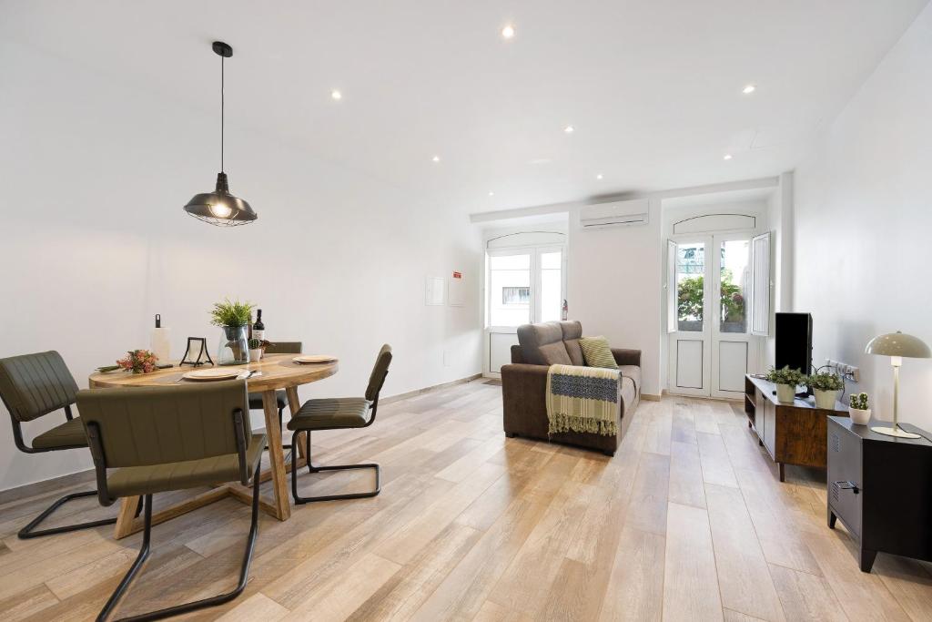 a dining room and living room with a table and a couch at Villa Xique 11 in Monchique