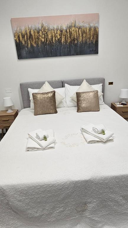 a large white bed with two napkins on it at A&D apartments in Bologna