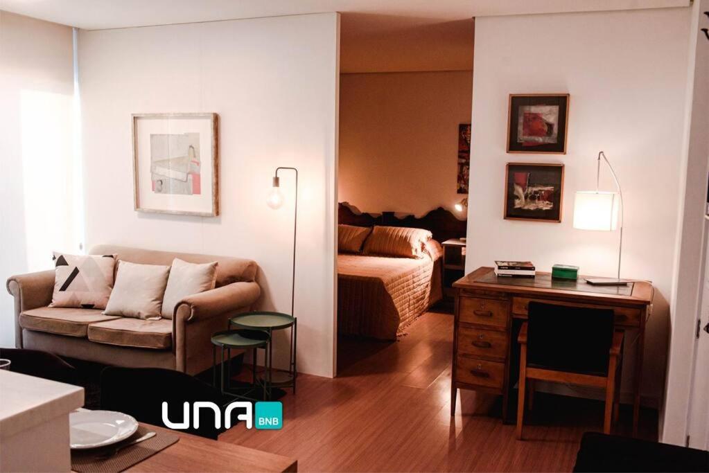 uma sala de estar com um sofá e uma mesa em Apartamento pura vida no Parque Una com vaga de garagem. em Pelotas