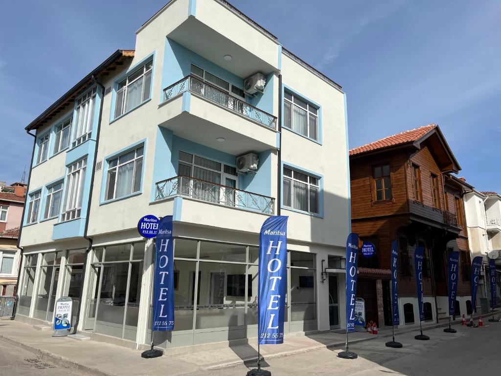 ein blau-weißes Gebäude mit Schildern davor in der Unterkunft Maritsa Hotel in Edirne