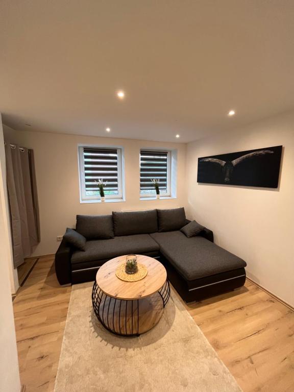 a living room with a couch and a coffee table at Moderne 2 Zimmer-Ferienwohnung in Nörten-Hardenberg