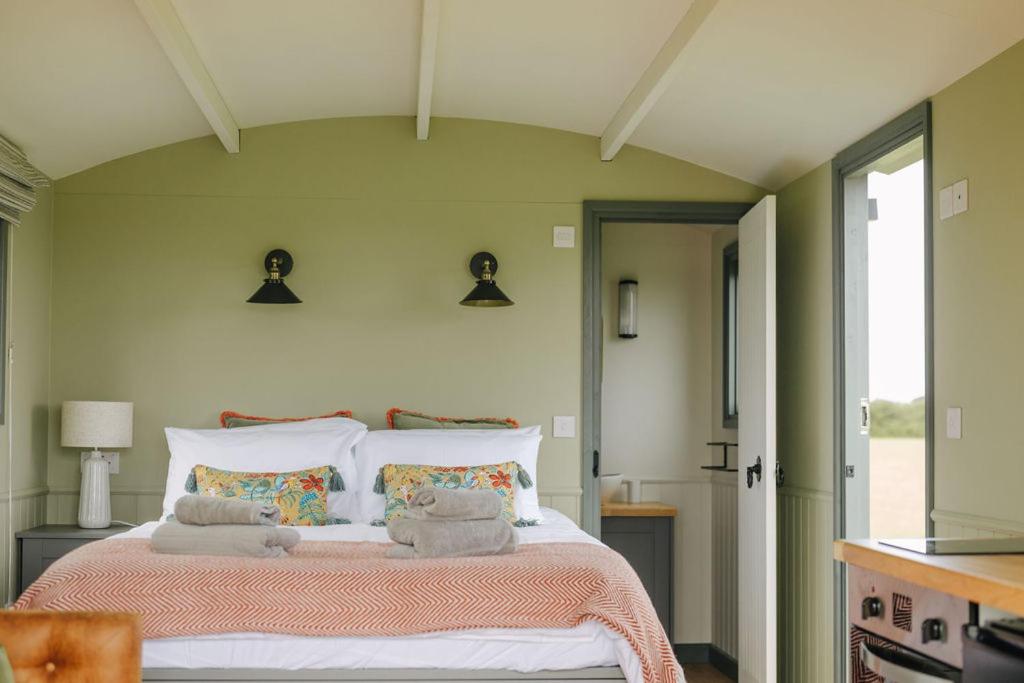 a bedroom with a large bed with towels on it at Clover Hut - Snettisham Meadows in Snettisham