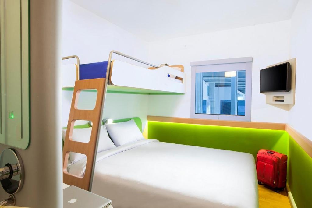 a bedroom with a bunk bed with a ladder at Cordia Hotel Makassar Airport in Makassar