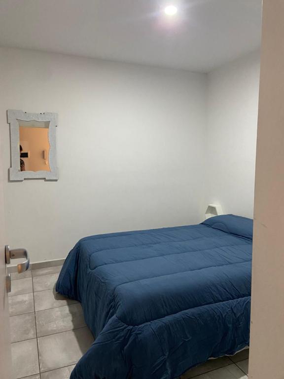 1 dormitorio con 1 cama azul en una habitación blanca en Súpercomodo en Rosario