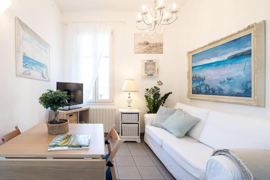 een woonkamer met een witte bank en een tafel bij [Art of Living] 100 meters from the sea. in Marina di Pietrasanta
